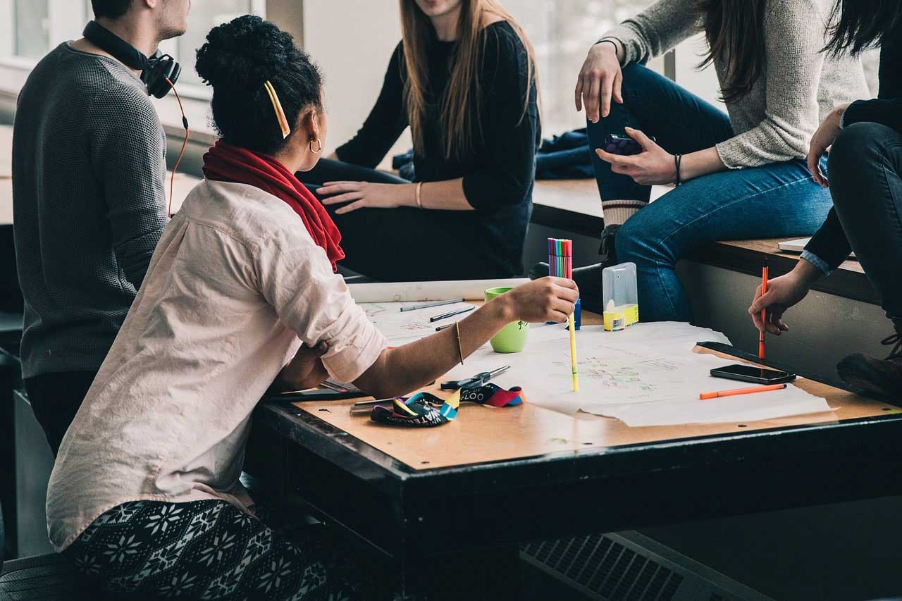 Vier Frauen und ein Mann im Gespräch – symbolisiert Recruiting-Strategien gegen den Fachkräftemangel.